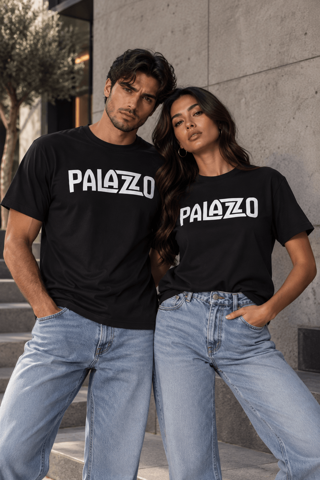 Schwarzes T-Shirt aus 100% Baumwolle mit weißem PALAZZO-Logo, lockeres Fit, für Streetwear, auf grauem Stadtmauer-Hintergrund